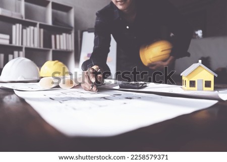 Architecture or Civil engineer analyze with construction blueprint. plan, engineer sketching a construction project, green energy concept