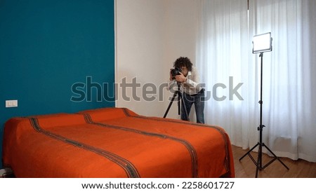 Italy, Milan - Real estate photographer man taking professional pictures and video of the bedroom for real estate agency - home staging to sell the house - renting a home for tourist  traveller