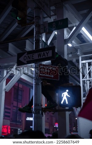 One way traffic sign, a person above the crowd