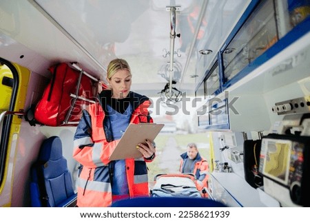 Young rescuer doctor checking equipment in ambulance car. Royalty-Free Stock Photo #2258621939