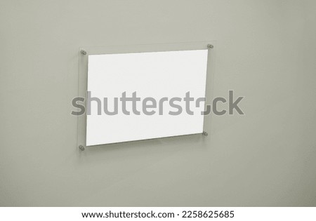 Empty white paper sheet in glass frame fixed on concrete wall. Information and advertising message.