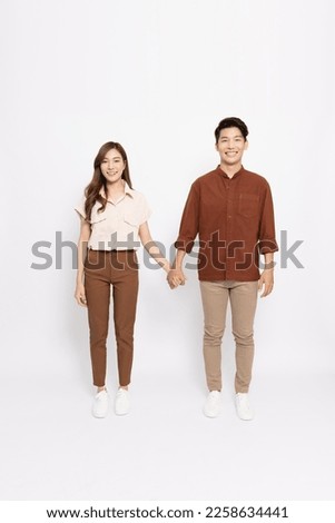 Portrait of Asian couple standing and holding hands together isolated on white background, Looking at camera