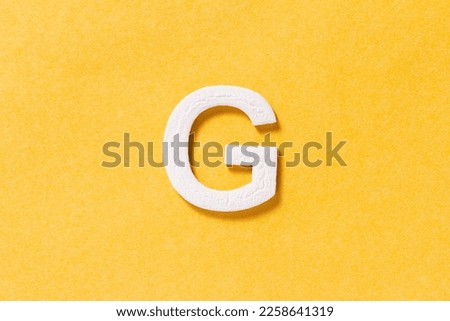 Letter G of the alphabet isolated on yellow background, top view Royalty-Free Stock Photo #2258641319