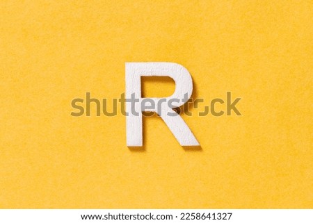 Letter R of the alphabet isolated on yellow background, top view