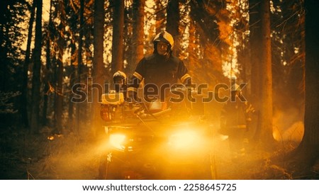 Professional Firefighters Crew Walking and Riding an ATV in Forest, Controlling a Wildland Fire Before it Becomes a Catastrophic Event. First Responders Arrive to the Forest and Assess the Situation. Royalty-Free Stock Photo #2258645725