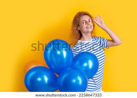party woman with balloon in sunglasses. woman smile hold party balloons in studio.
