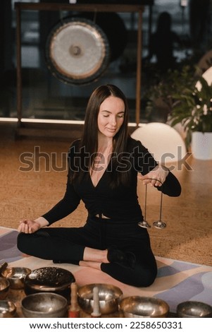 A woman holds Tibetan bells for sound therapy in her hands. Tibetan cymbals. Royalty-Free Stock Photo #2258650331