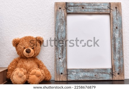 wooden photo frames and box next to soft teddy bear on wooden table
