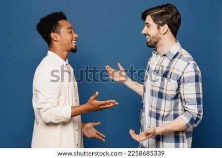 Side view young two friends smiling happy cheerful fun cool men 20s wear white casual shirts talk speak together isolated plain dark royal navy blue background studio portrait People lifestyle concept Royalty-Free Stock Photo #2258685339