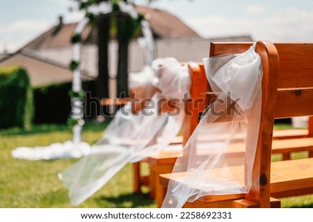 Decorated meadow for wedding ceremony. Wedding. Banquet. The chairs and round table for guests, served with cutlery, flowers. wedding ritual