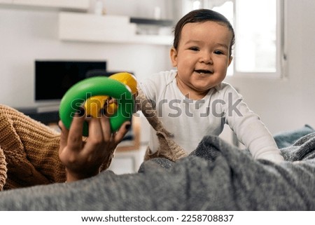 Stock photo of cute baby playing with her toys in the sofa and having fun.