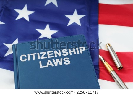 Law concept. On the US flag lies a pen and a book with the inscription - CITIZENSHIP LAWS