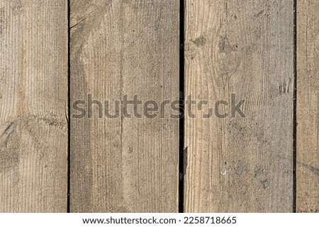 The texture of brown boards with knots and yellow sand