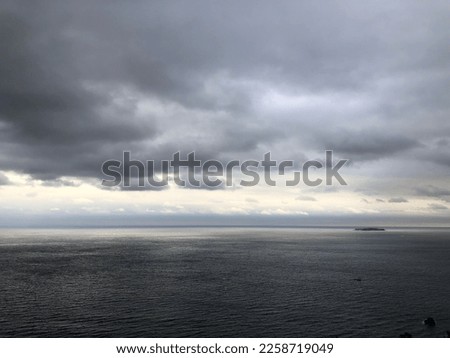 Raining sky over the sea. Cloudy sky atmosphere. Natural weather moment in rainy day.Natural gloomy sky weather background. Dramatic storm cloudy and dark sky.  Royalty-Free Stock Photo #2258719049