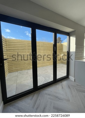 Herringbone flooring and tri fold doors blue sky and modern fencing