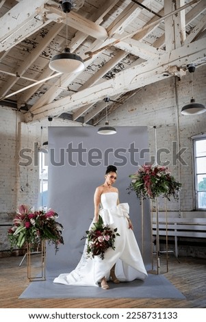 Beautiful bride in white tailored designer gown and tropical floral arrangements with anthurium and peony flowers