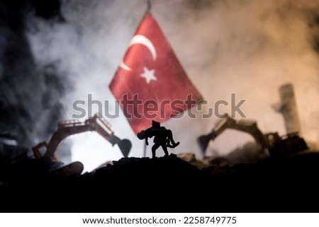 Turkey Earthquake happend in February 2023. Decorative photo with Turkish flag, and ruined city buildings. Pray for Turkey. Selective focus Royalty-Free Stock Photo #2258749775