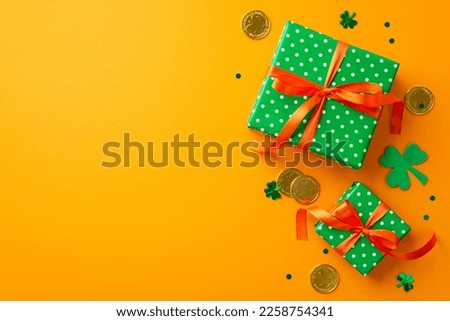 Saint Patrick's Day concept. Top view photo of green present boxes with orange ribbon bows clover gold coins and trefoil shaped confetti on isolated yellow background with empty space