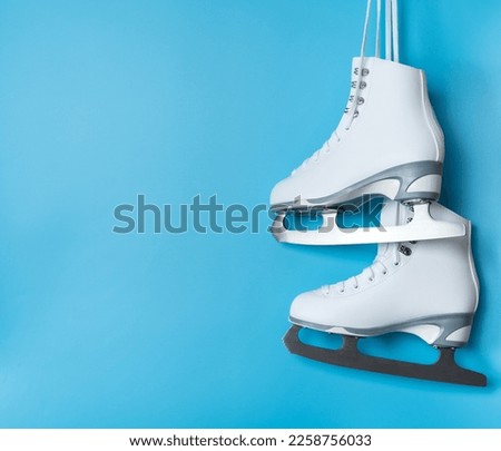 Pair of white figure ice skates shoes on blank blue background