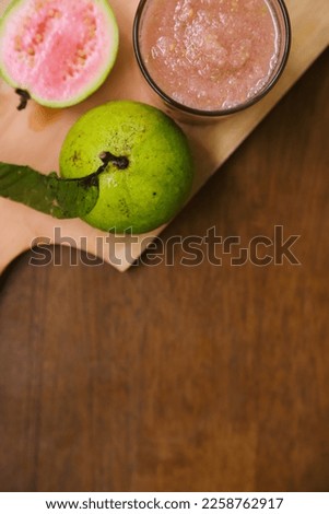 Flat lay of fresh guava fruit and guava juice served on a wooden table