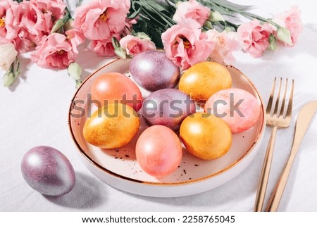 Multicolored painted Easter eggs in pastel colors in a plate on a white cotton tablecloth