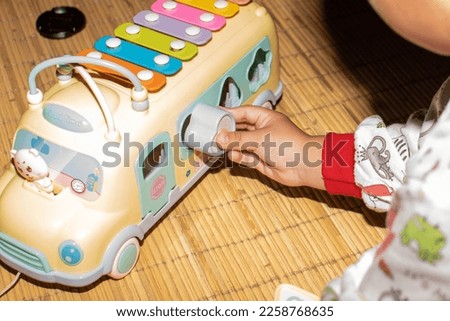 A toddler boy playing with an alphabet school bus toy
