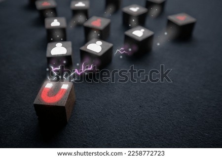 A wooden block with a magnet icon is attracting more blocks with a people icon. marketing ideas The technical strategy has caught the attention of many people. Royalty-Free Stock Photo #2258772723