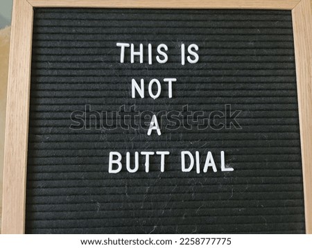 A sign saying this is not a butt dial. The felt sign has removable letters than can be moved around to make whatever words or saying one wants. 