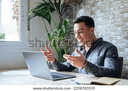 Concentrated skilled millennial caucasian businessman in glasses wearing headphones with mic, taking part in online web camera negotiations meeting using computer app, distant communication concept. Royalty-Free Stock Photo #2258783519