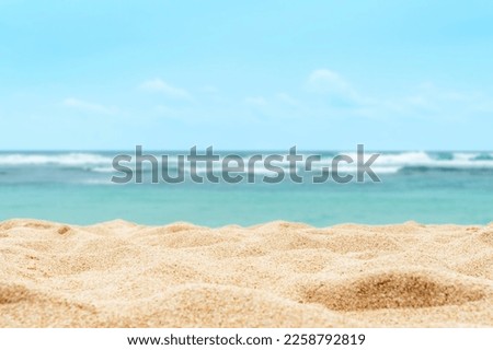 Empty sandy beach in the background with a blurry summer sea.  Royalty-Free Stock Photo #2258792819