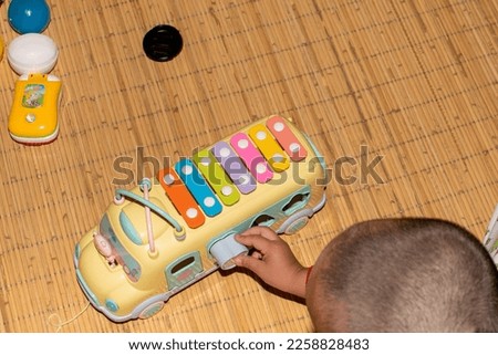 A toddler boy playing with an alphabet school bus toy
