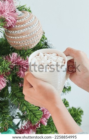 Woman holding hot chocolate cup.