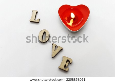 Candle in the form of a heart and the inscription love