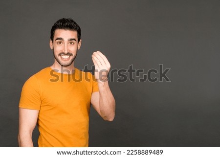 Studio portrait with grey background of a caucasian man with a typical Italian gesture Royalty-Free Stock Photo #2258889489