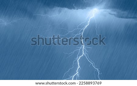 Lightning strikes between stormy clouds with rain