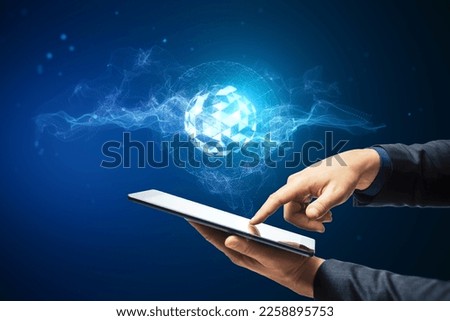 Close up of businessman hand pointing at creative glowing metaverse hologram on blue background. Digital world and future concept