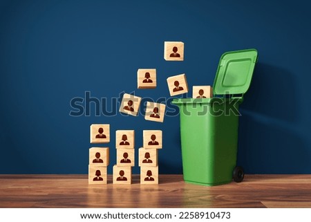 Visual metaphor of mass layoffs and redundancies, human resources concept. Dismiss from employment. Wooden cubes with employees represented by symbols and garbage can. Royalty-Free Stock Photo #2258910473