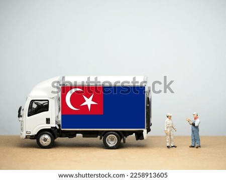 Mini toy at table with white background. Industrial shipping concept. Johor flag design, is a state of Malaysia in the south of the Malay Peninsula.