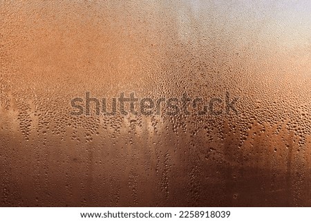 Background of water drops, condensation on the glass. water drops on a brown-golden background.