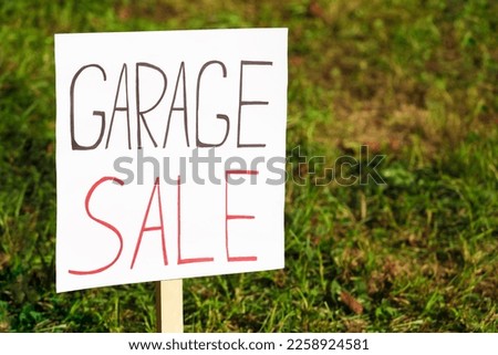 Sign Garage sale written on cardboard near grass, closeup. Space for text