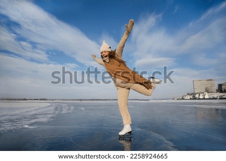 cheerful  woman  ice skating on a frozen river  in winter nature. Enjoying the little things. Winter Vibes. christmas holiday
