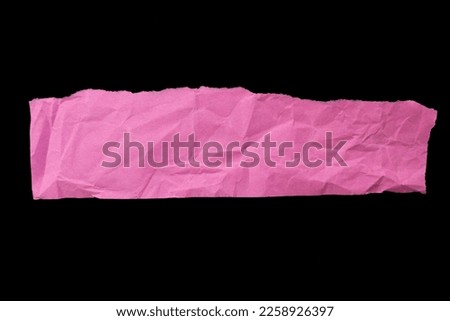 Crumpled torn pink paper piece isolated on black background. Ripped paper with copy space for text.