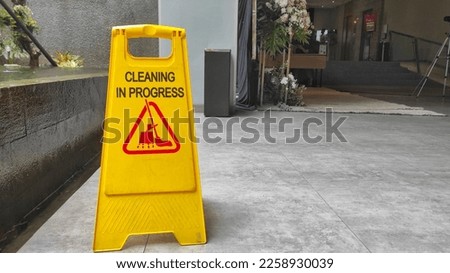 Yellow plastic cleaning in progress sign on the floor to show that the room in cleaning process Royalty-Free Stock Photo #2258930039