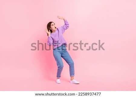 Full length photo of pretty shocked girl dressed purple pullover catching arms falling sky empty space isolated pink color background