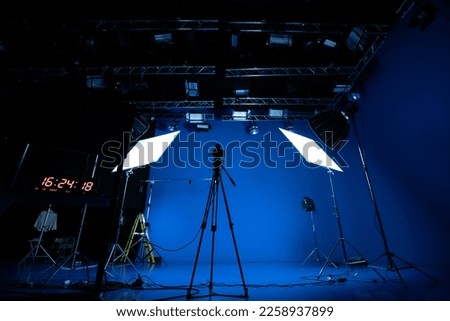 Professional video studio behind-the-scenes video footage behind-the-scenes silhouette production photography with a focus on camera and studio equipment. Royalty-Free Stock Photo #2258937899