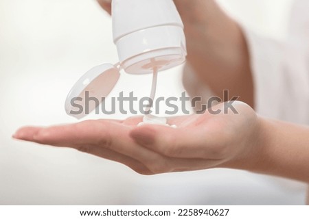 Close up woman hands squeeze cream or lotion drop on hand before apply on her face. Self care of young healthy female apply cream on body after shower for moisturizing on skin. Woman self care concept Royalty-Free Stock Photo #2258940627