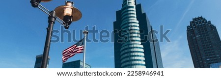 low angle view of lantern and usa flag near skyscrapers under blue sky in New York City, banner