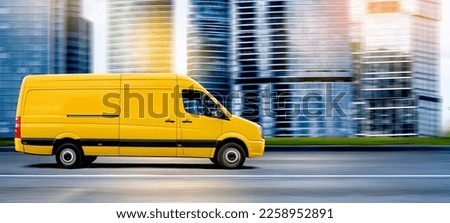 Yellow van driving in front of a modern cityscape. Small truck delivers the goods