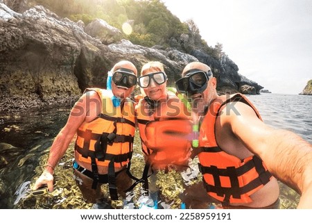 Mother and father with son taking selfie at snorkel excursion in Thailand - Adventure travel concept with family sharing moments in south east asia - Defocused water drops as part of composition 