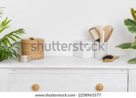 Hair brushing and make up items on wooden dressing table Royalty-Free Stock Photo #2258965577